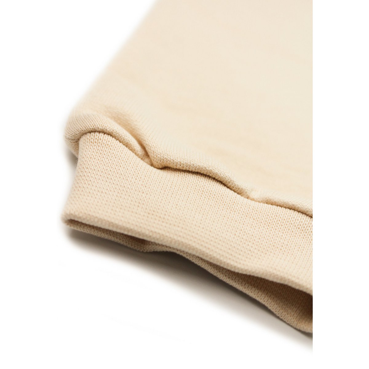 Kind draagt het beige trainingspak