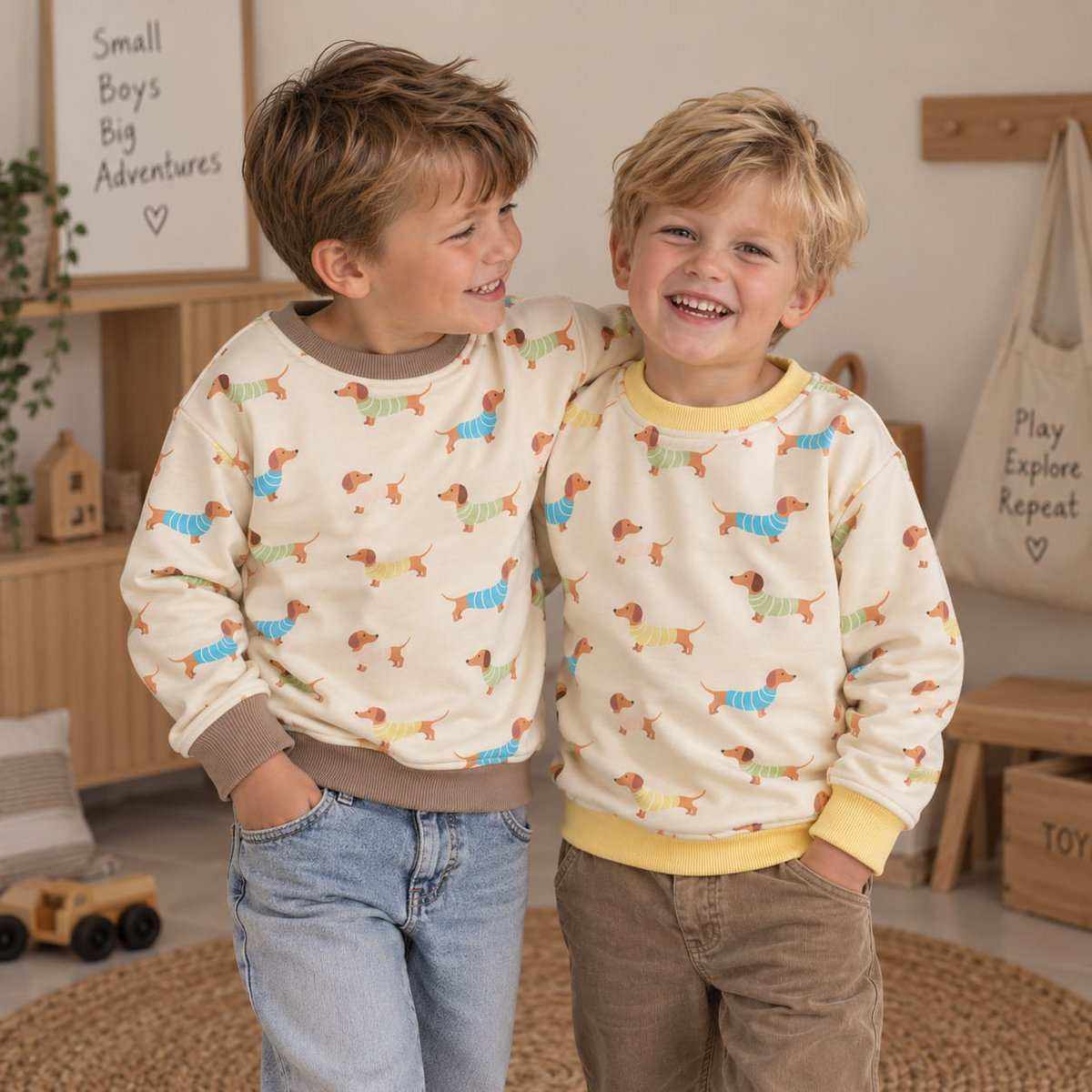 Kindersweater Teckelprint crème kleur met vrolijke allover teckelprint in pastelblauw, geel, groen en roze, ronde hals